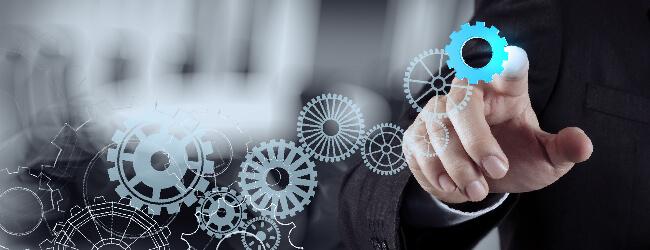 Abbildung: Geschaeftsmann dreht Zahnraeder mit Zeigefinger