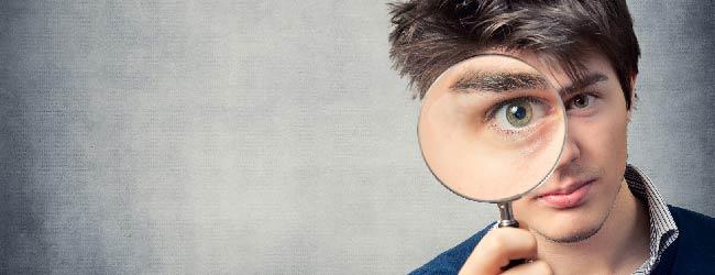 Abbildung: Mann sieht durch eine Lupe