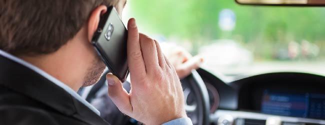 Abbildung: Geschaeftsmann mit Handy am Ohr im Auto