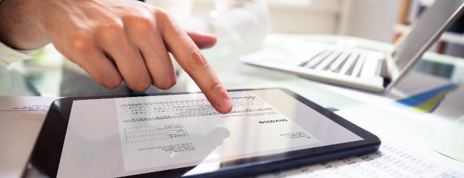 Abbildung: finger zeigt auf digitale rechnung im tablet