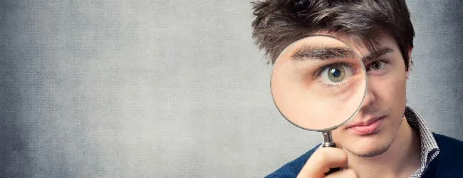 Abbildung: Mann sieht durch eine Lupe