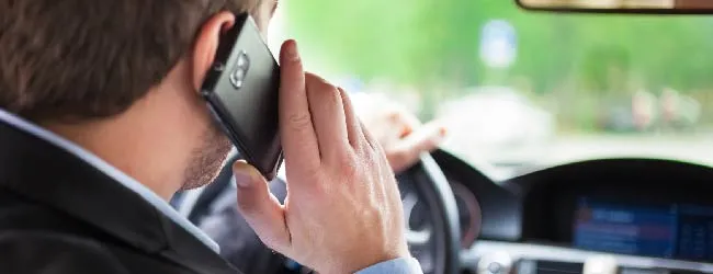 Abbildung: Geschaeftsmann mit Handy am Ohr im Auto